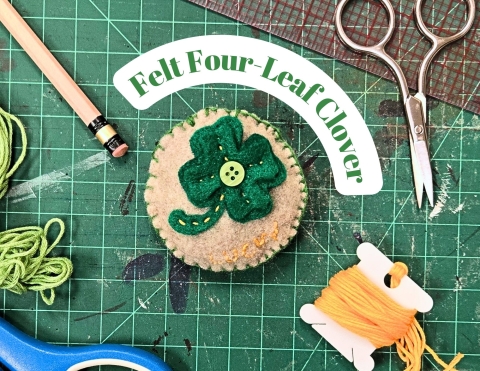 a felt brooch with a green four-leaf clover.